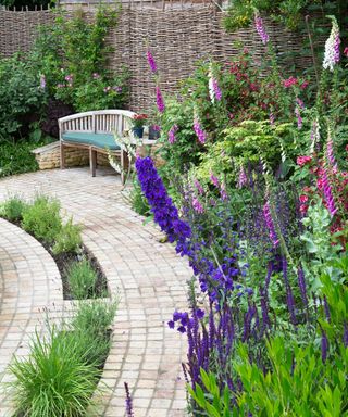Curved flower border and block paving in an english cottage garden