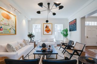 A living room with a pendant light and recessed lighting