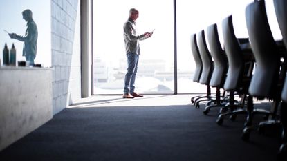 A man stands alone in a boardroom