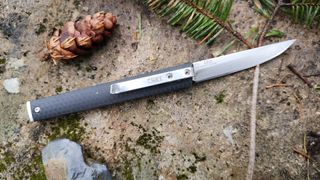 CRKT CEO Heinnie Haynes Edition camping knife on rock outdoors