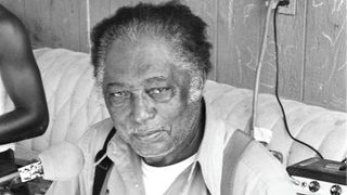 R.L. Burnside plays guitar at his home in Chulahoma, in 1998.