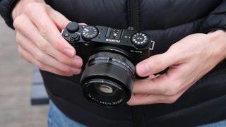 Fujifilm X-M5 with a Fujifilm 35mm lens attached camera held in a pair of hands