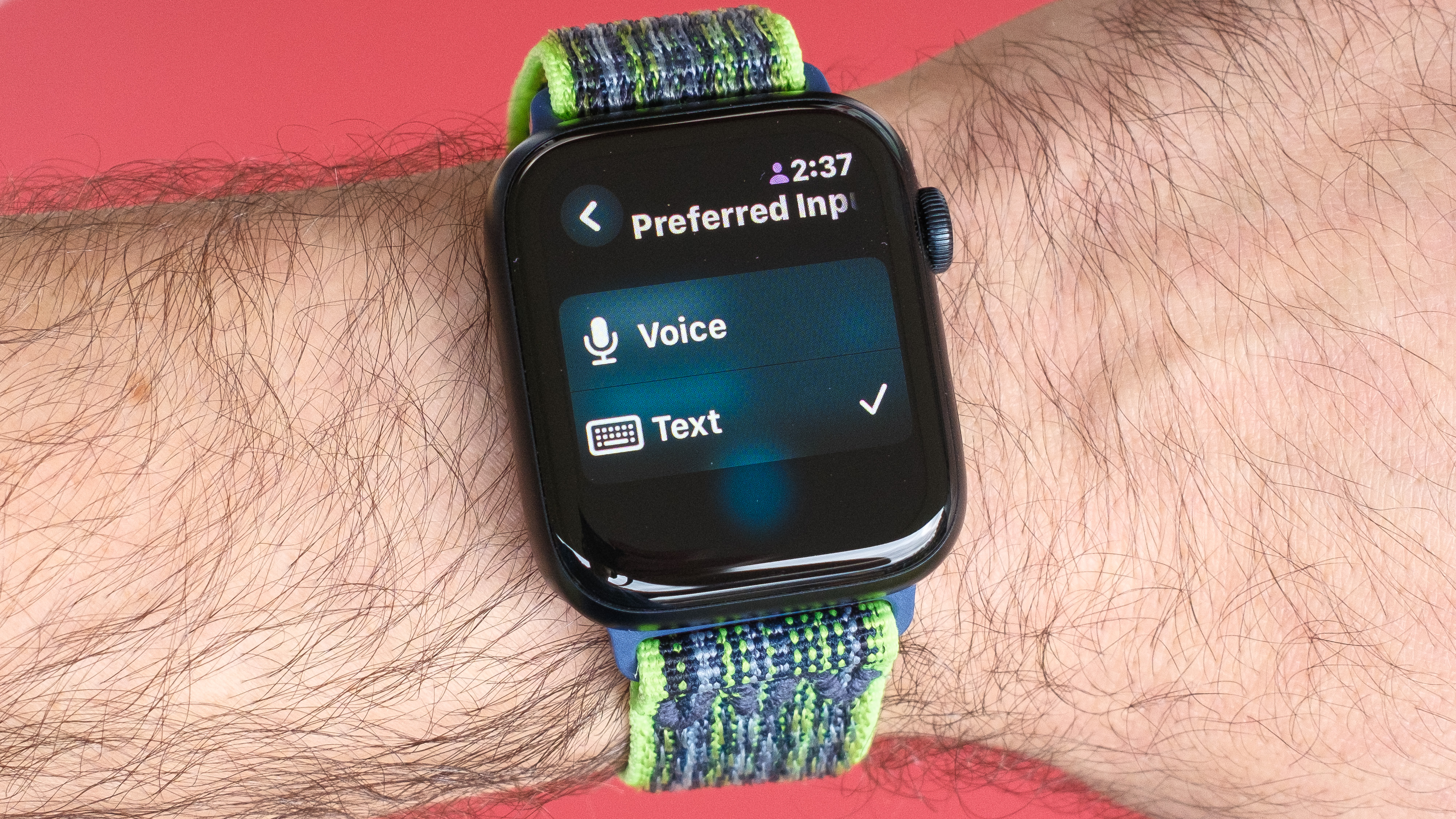 Close-up of an Apple Watch SE 2022 against a red background with the new Translate app on the screen