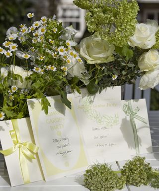 White cut flowers with pretty hand written invitations to a garden party