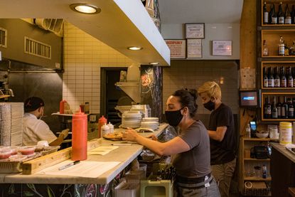 Restaurant staff wearing the protective masks work in the kitchen as the city reopens from the coronavirus lockdown on June 15, 2020 in Hoboken, New Jersey