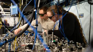Quantinuum scientists making adjustments to a beam line array used to deliver laser pulses in H-Series quantum computers