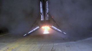 the first stage of a rocket touches down on its landing legs on an ocean-based droneship