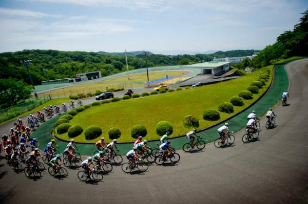 Riders pass in front of the Keirin school and training bank