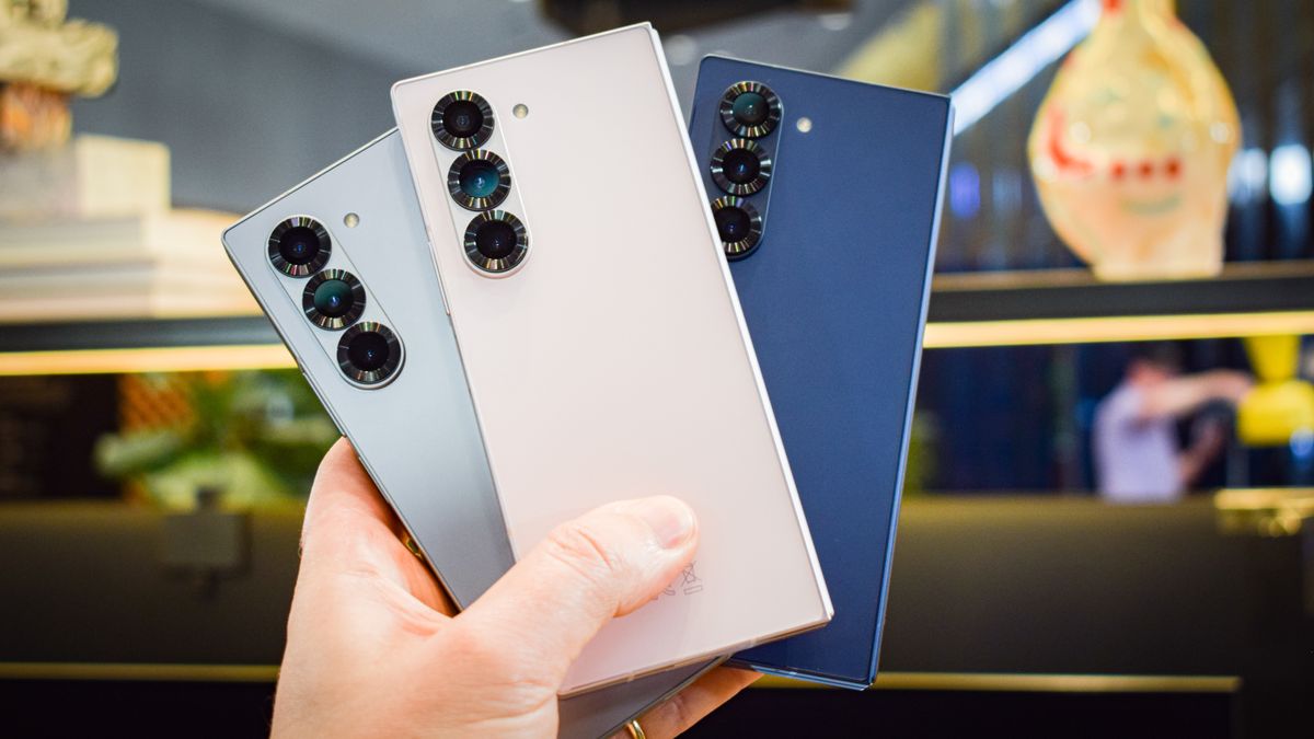 A hand holding three Samsung Galaxy Z Fold 6 smartphones in three colorways