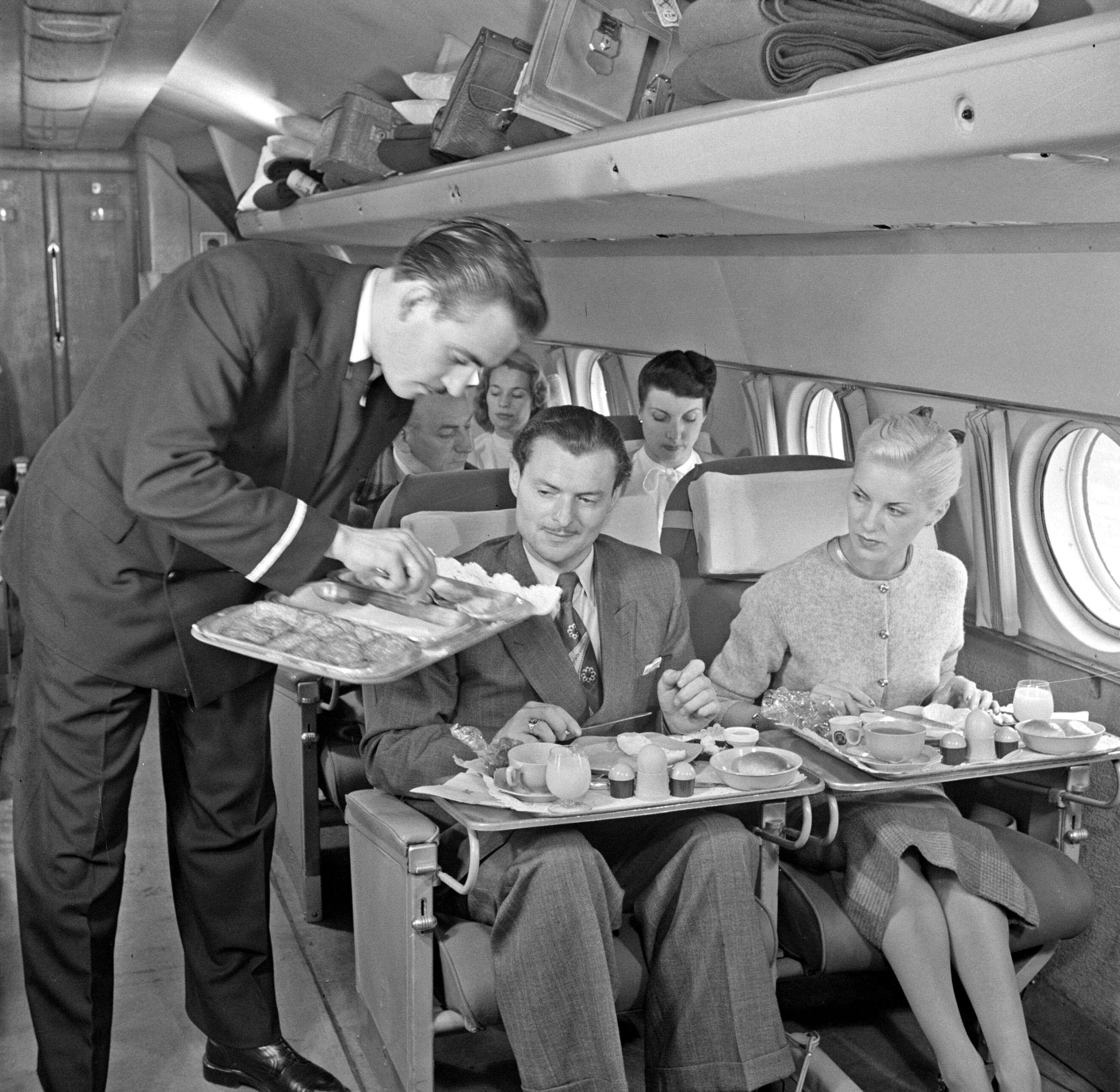 A KLM purser serves the meal during the flight in a KLM passenger plane.