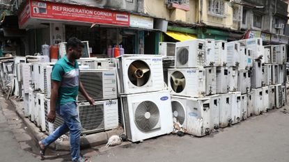 A man walks past a slew of air conditioners for sale at a market in Kolkata, India.