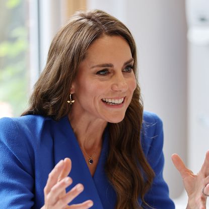 Princess Kate wearing a blue dress and smiling 