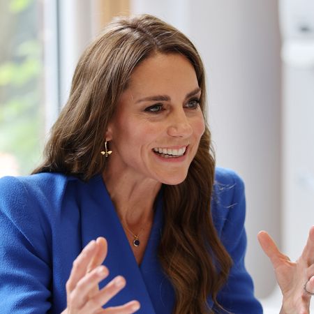 Princess Kate wearing a blue dress and smiling 