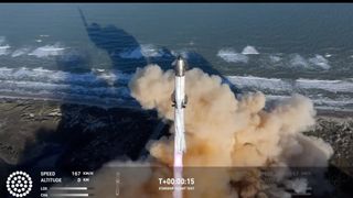 a giant rocket launches into a blue sky from a seaside pad