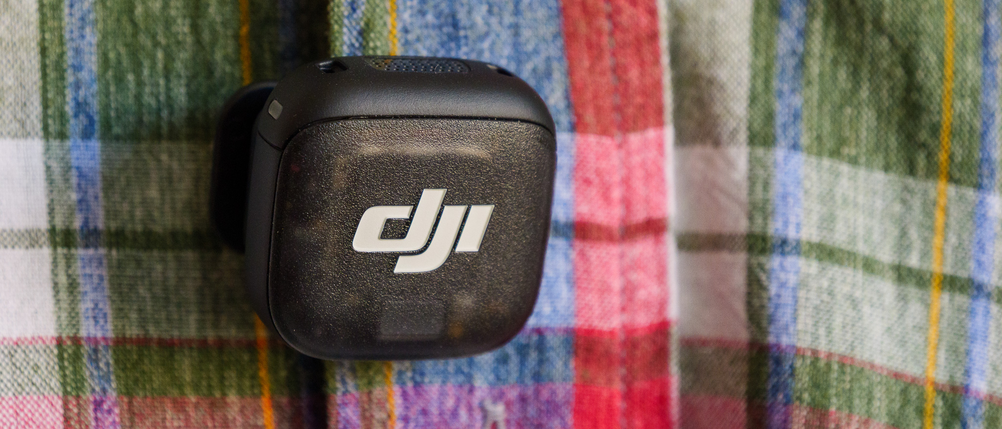 DJI Mic 3 wireless microphone attached to colorful plaid shirt