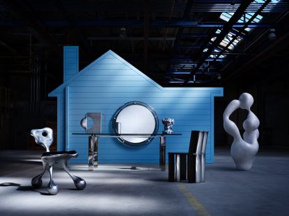 A blue American house forming the backdrop for shiny metal American furniture design