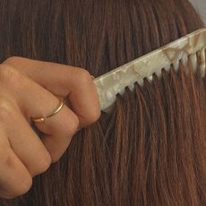 A woman using a chic comb throughout her hair