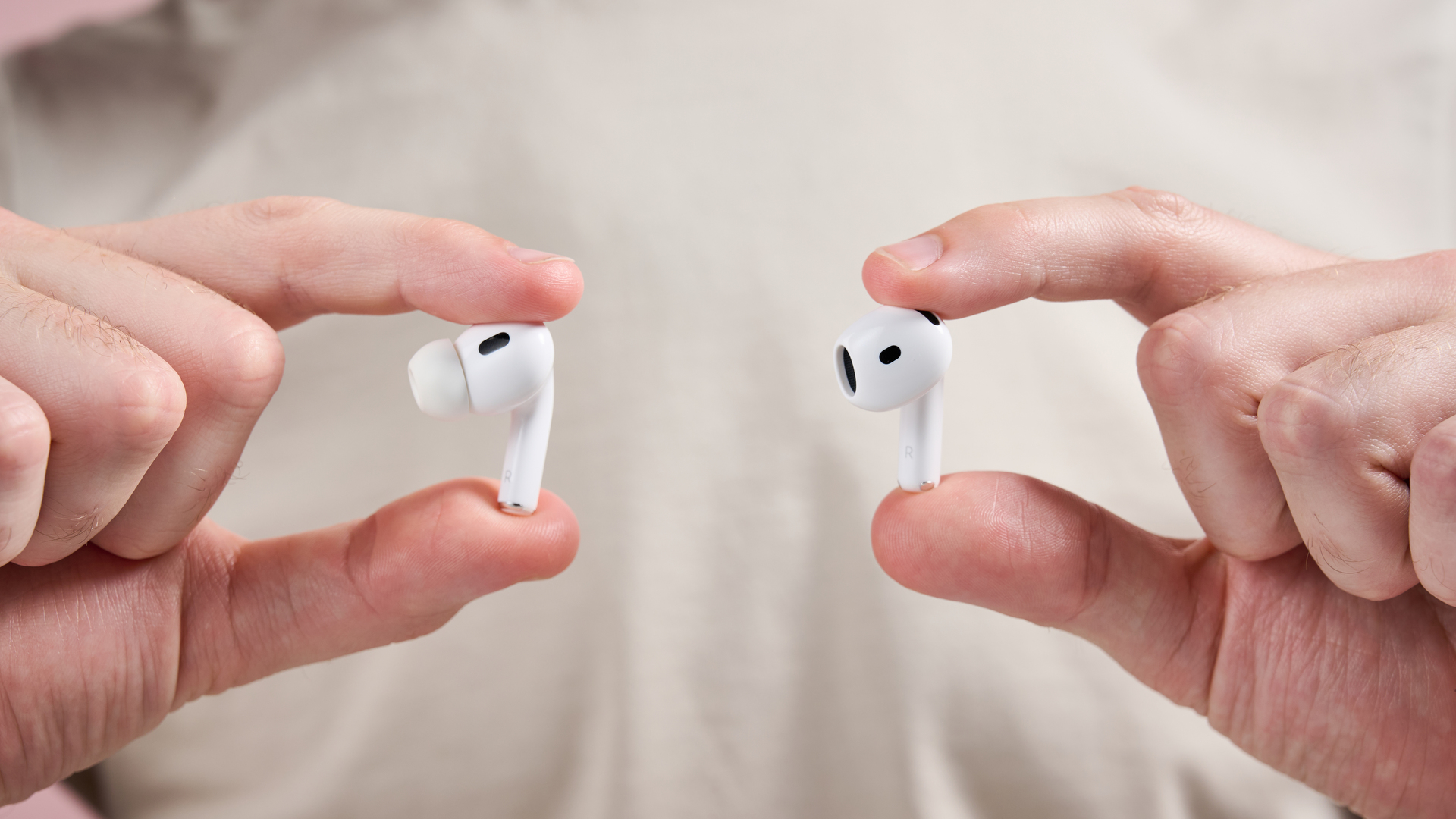 AirPods Pro 2 and AirPods 4 being held up next to each other