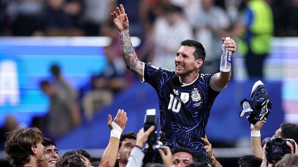 Lionel Messi, wearing Argentina's dark blue away kit, sits on top his team-mates' shoulders after his team reaches the FIFA World Cup Final 2026
