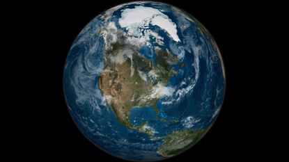 A view of Earth from space, with whisps of clouds drifting over the North American continent