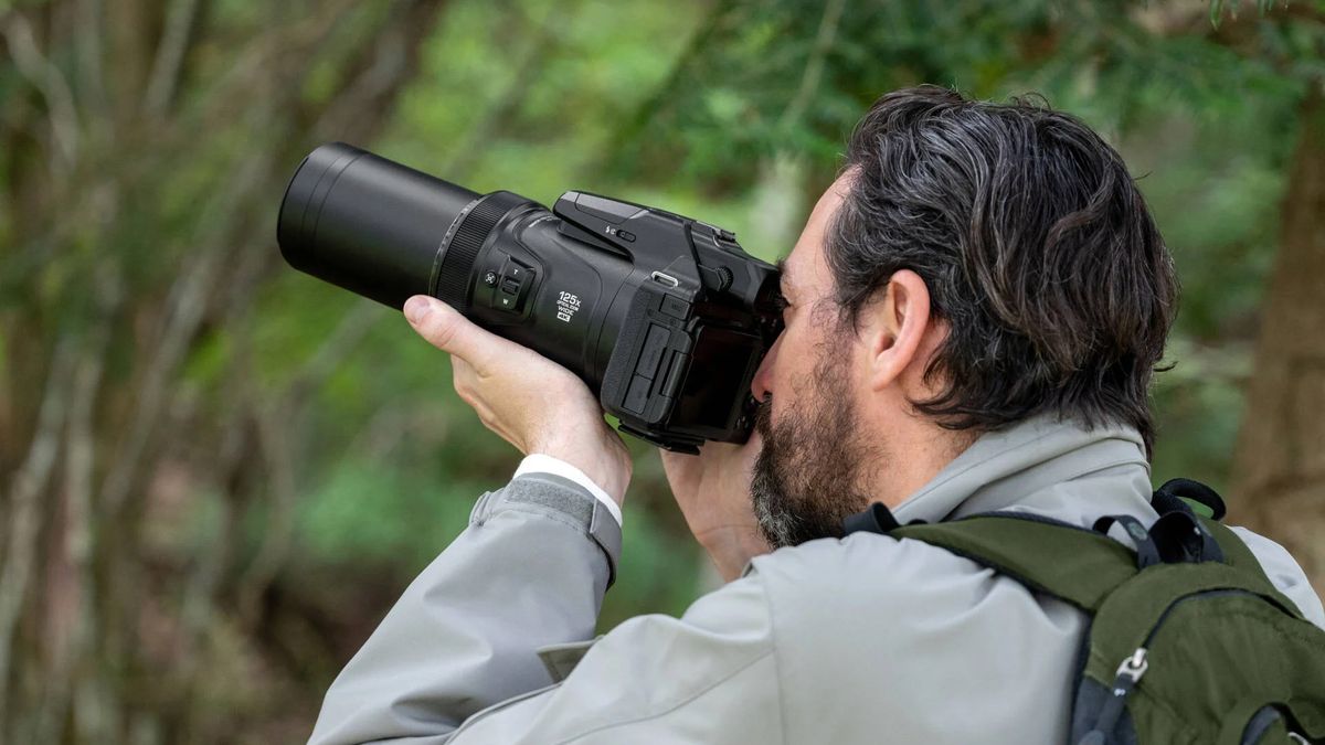 Photographer using a Nikon Coolpix P1100 in a woodland setting