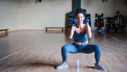 Woman performs a dumbbell squat