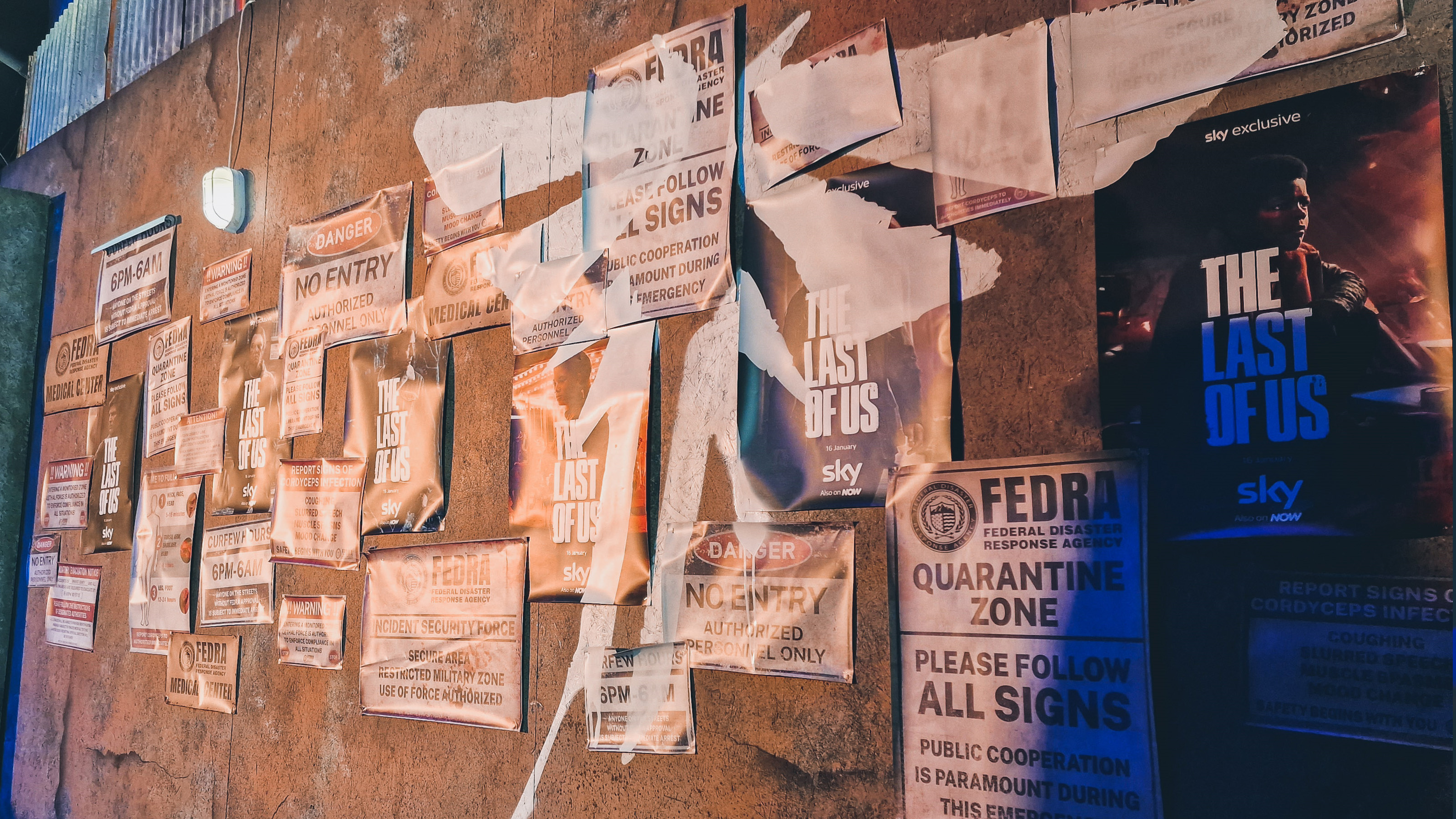 Una toma de varios carteles y material promocional para el espectáculo Last of Us en una pared en ruinas