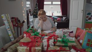 Casualty Robyn at home surrounded by Christmas presents