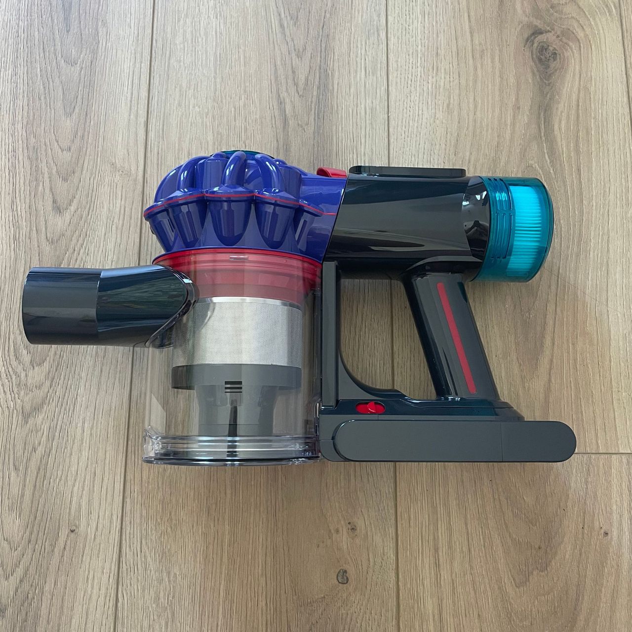 Handheld section of the Dyson V10 Konical Cordless Vacuum laying on wood-effect flooring
