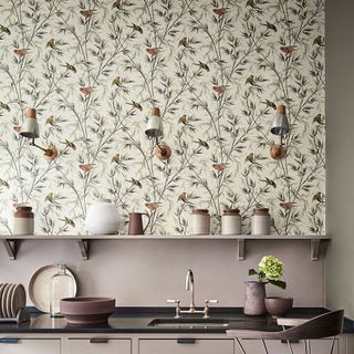 kitchen with wallpaper on wall black countertop with plates and clay tins