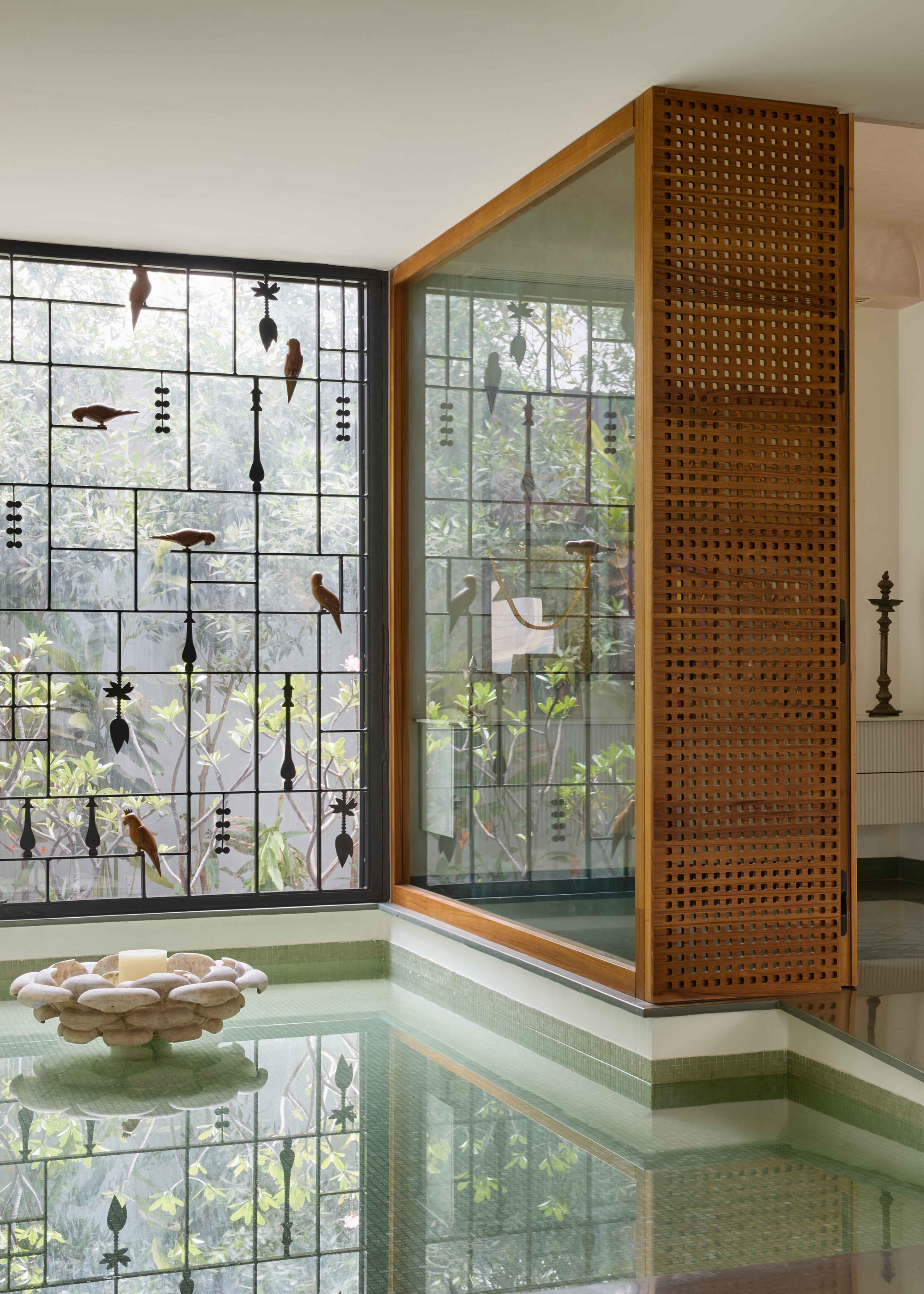 A calming prayer room with a glass window, a shallow water feature, and a braided wood wall