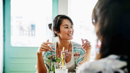 Table, Happy, Drink, Tableware, Black hair, Drinkware, Alcoholic beverage, Necklace, Distilled beverage, Highball glass, 