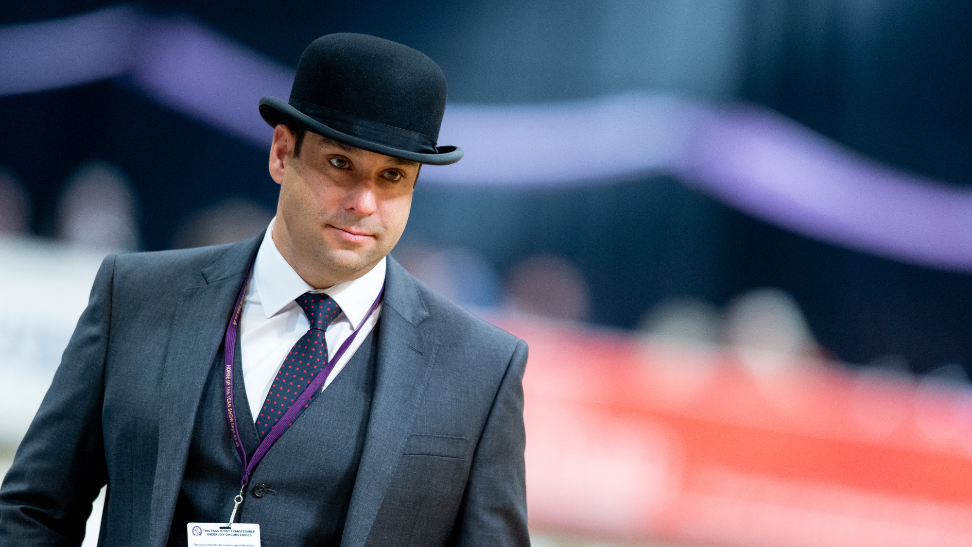 Graham Dunkley is wearing a bowler hat and suit while assessing the coloured horses at HOYS in 2019