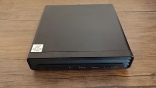 A black compact HP EliteDesk 800 desktop PC sitting on a brown wooden table