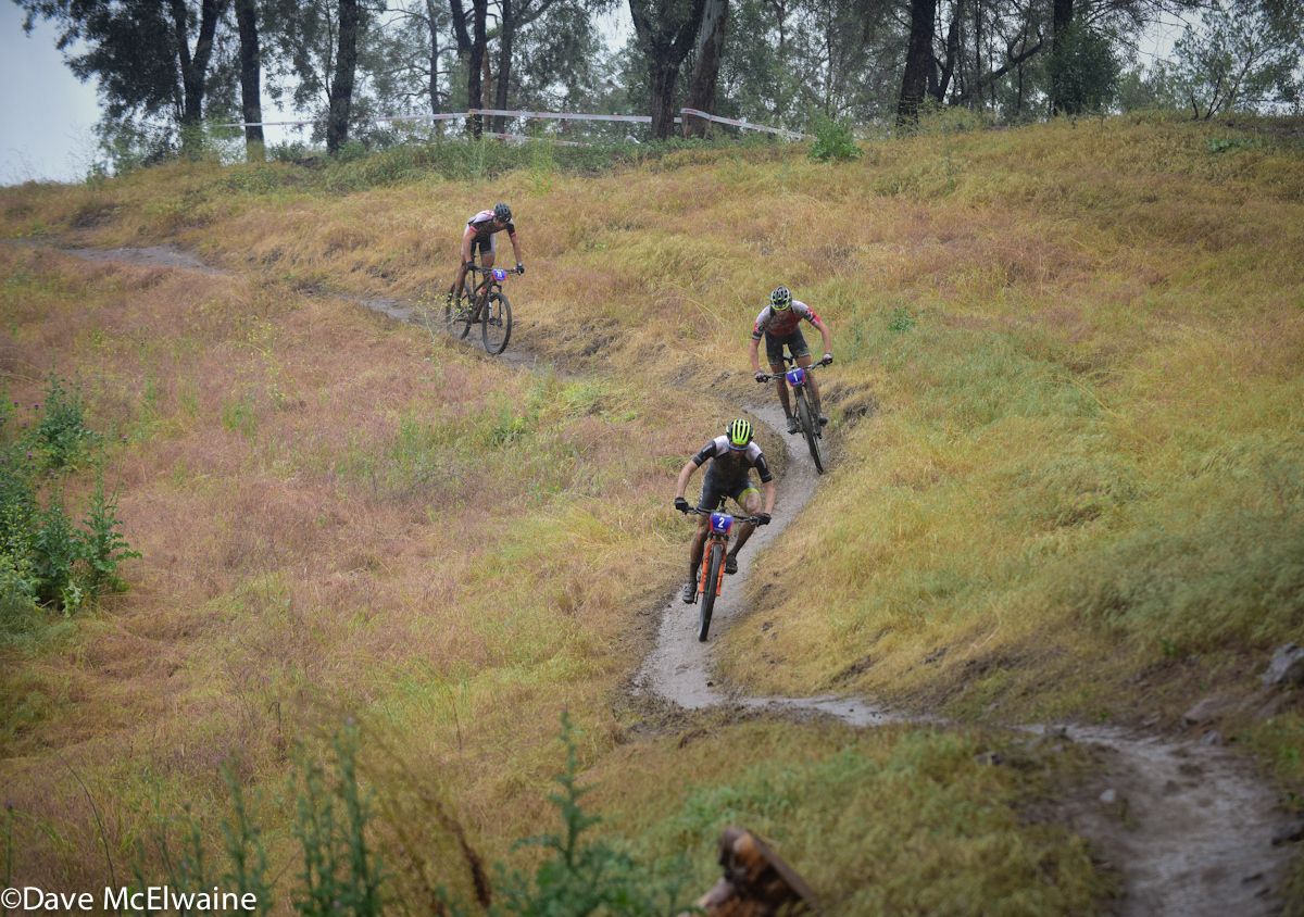 Riders descend a slick twisty singletrack