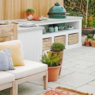 White garden furniture on patio with plant pots