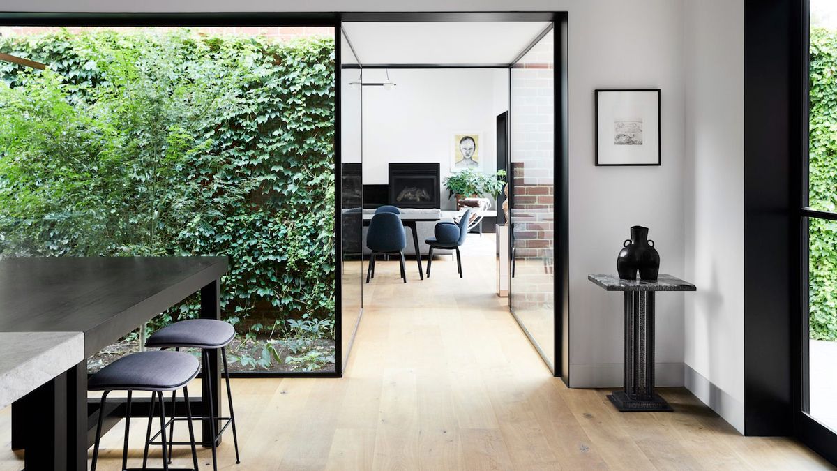 Une maison historique de Melbourne remise au goût du jour avec des fenêtres à ossature d'acier du sol au plafond et une palette monochrome