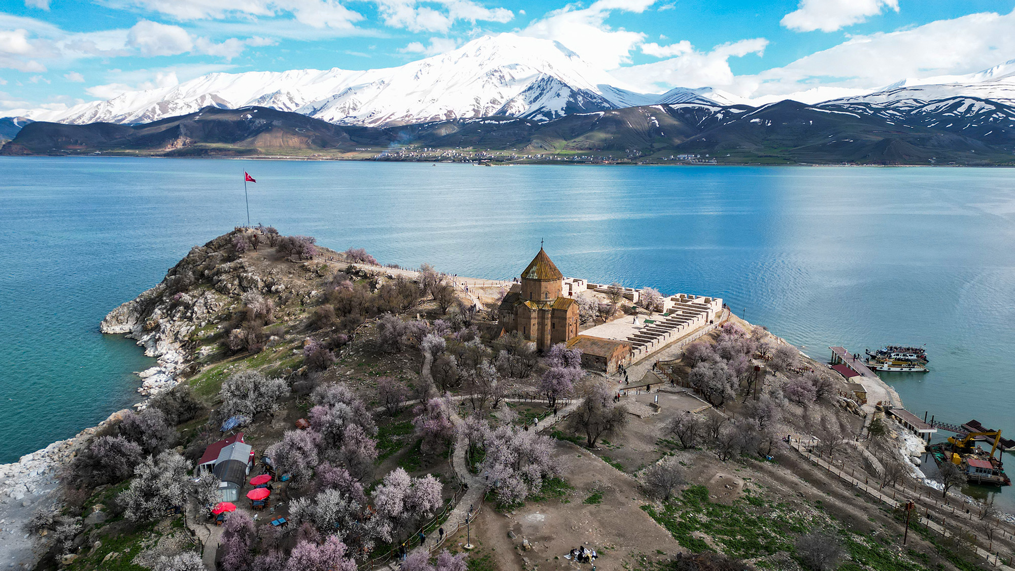 Almond trees bloom on Akdamar Island, with snow-covered Mount Artos seen in the background in Van, Turkiye