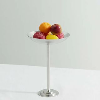 A tall silver cup filled with fruits.