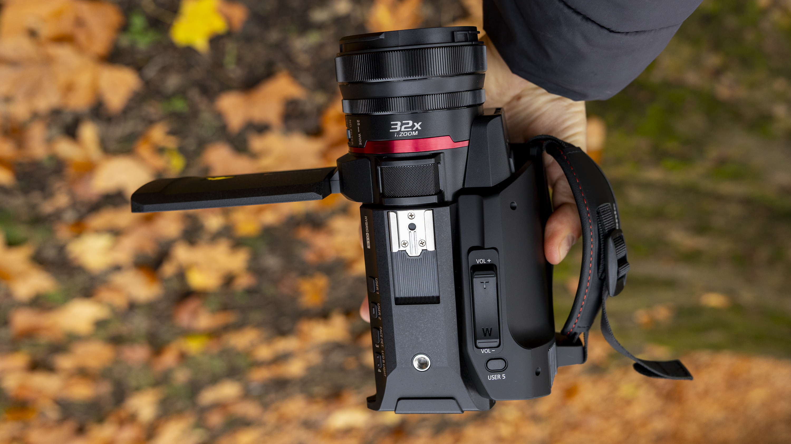 The Panasonic HC-X1200 camcorder held by a female photographer against an orange autumnal backdrop