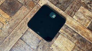 Fitbit Aria Air smart scale on wooden floor
