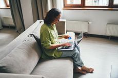 Smiling woman with credit card next to laptop