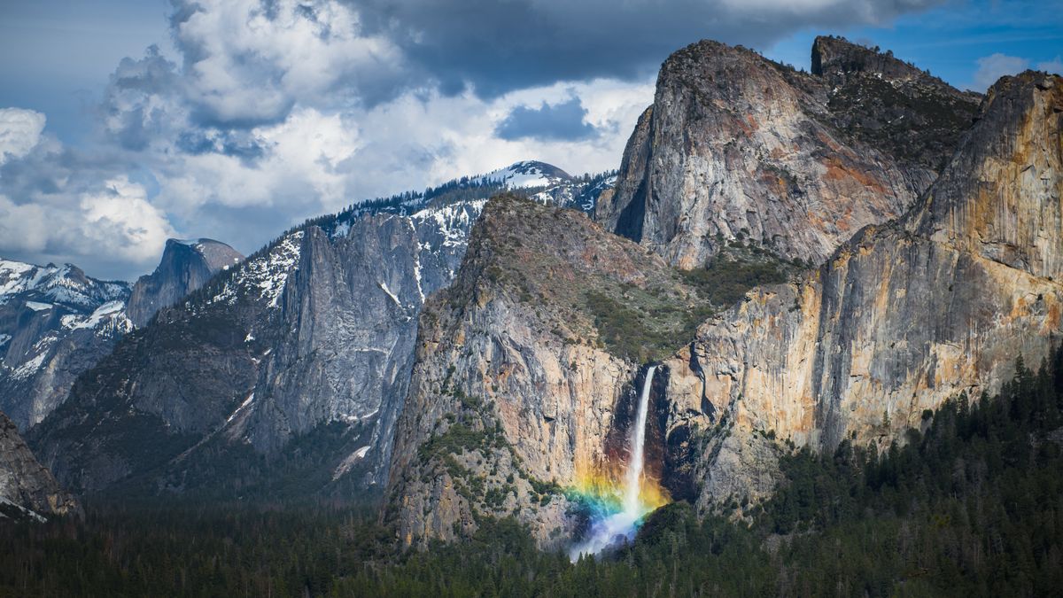 A rainbow emerges from the mist at the base of Bridal Veil Falls in California&#039;s Yosemite National Park