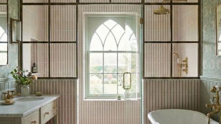 A large bathroom covered in pink and white tiles in a stripe layout
