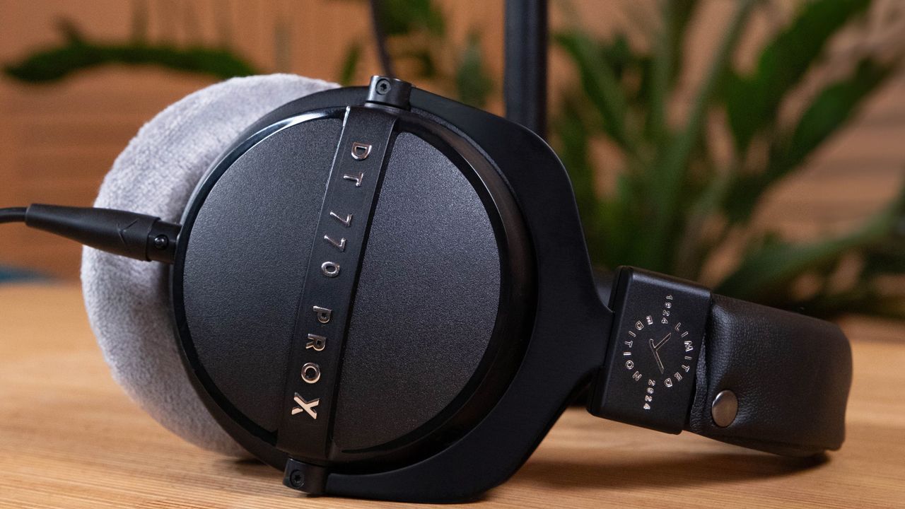 The Beyerdynamic DT 700 Pro X over-ear headphones lying on a wooden surface. These are our pick for best studio audiophile headphones.