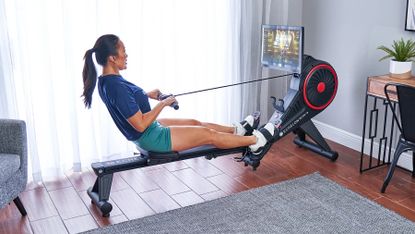 Woman rowing on Echelon Row-S rowing machine in a home