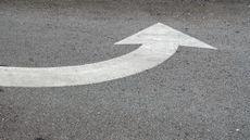 white curved arrow painted on asphault road