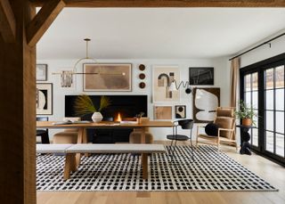 Black, white, and neutral dining room with lots of art on the ways and wood accents