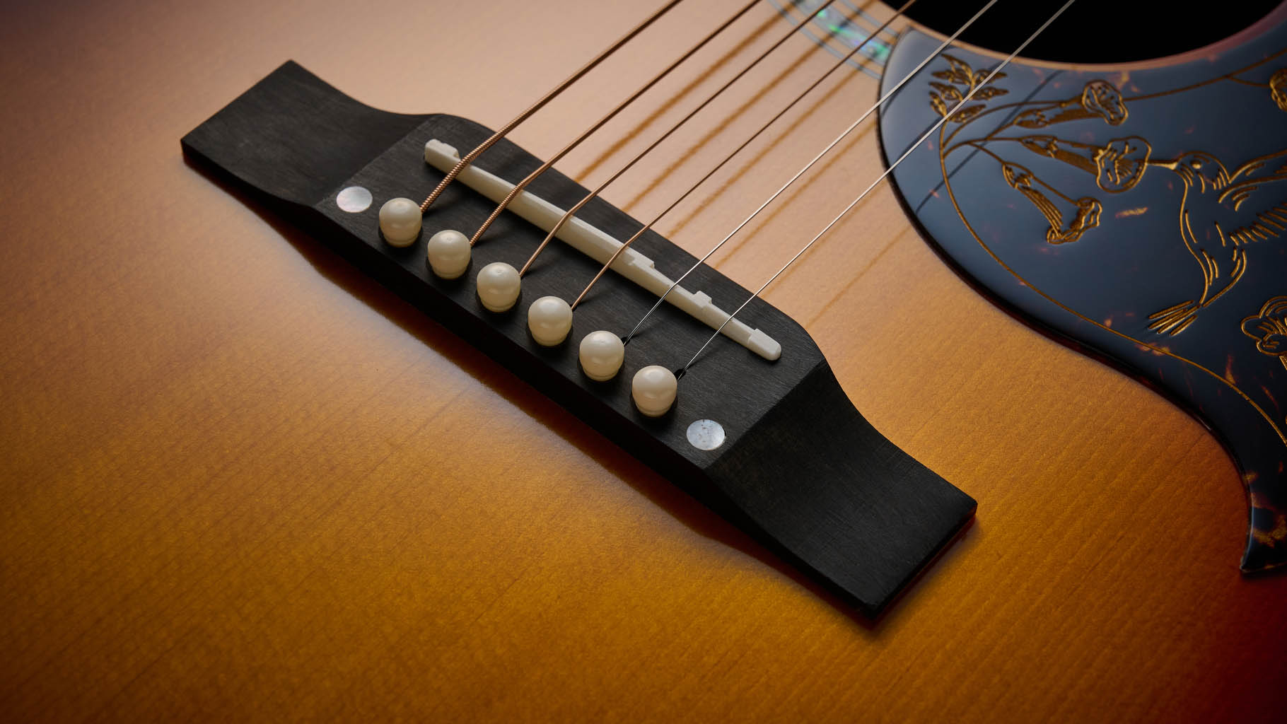 The Epiphone Inspired by Gibson Custom Hummingbird photographed in all its glory, in close-up and against a wheat-coloured rug.