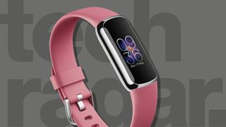 Fitbit Luxe mit rosa Band auf grauem Hintergrund
